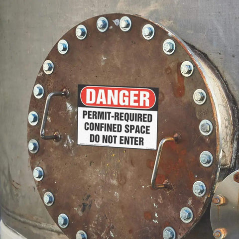 Permit Required Confined Space Danger Sign 10X7 Inches OSHA Compliant Wall Plate mounted on a metal surface with bolts.
