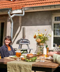 Group enjoying backyard with Multi Fuel Outdoor Pizza Oven For Wood And Gas With 12 Inch Pizza Stone And Integrated Thermometer