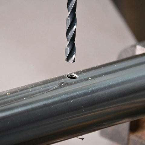 1/4 Inch By 8 Inch Long Drill Bit With Black Oxide Coating And Cobalt Alloy, shown drilling into a metal surface
