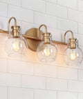 Over Mirror Gold Bathroom Light Fixture With Three Clear Glass Globe Shades Modern Minimalist Vanity Lighting on tile wall