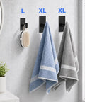 Five Pack Heavy Duty Adhesive Wall Hooks With Removable Strips holding towels and brush in bathroom, black stainless steel 304.