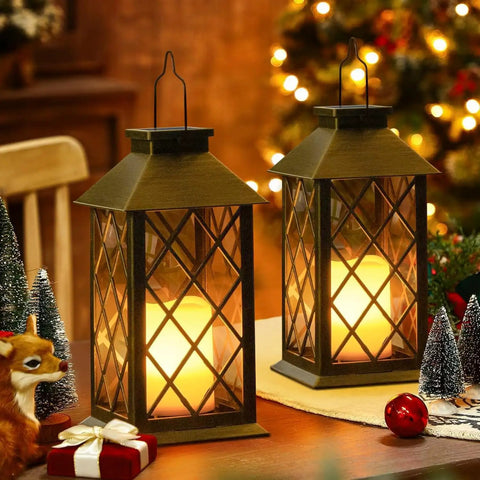 Two bronze metal leaf pattern solar lanterns on a table, lit at night, Solar Lanterns Outdoor Waterproof Garden Lanterns With Metal Leaf Pattern Dusk To Dawn Solar Powered Hanging Lights For Patio Garden Table Decor Great Mothers Day Gift For Mom Wife Grandma. Decor, gift box, and mini trees around.