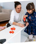 Child and adult assembling furniture with four piece woodworking strap clamp blocks in home workshop setting