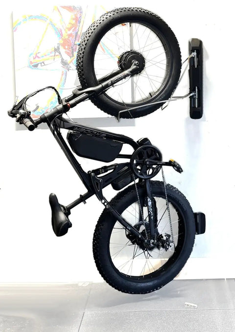 Swivel Wall Mount Bike Rack For Indoor Storage With Space Saving Design And Swivel Arms No Fuss Easy Roll In Access For Home Garage And Bike Park Fits Road Bikes Up To Two Point One Inch Tire Width displaying a black bike vertically on a white wall.