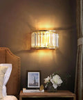 BUNCC Modern Minimalist Metal Wall Sconce, E14 LED Crystal Indoor Wall Light Fixture mounted beside a bed in a cozy decor setting.