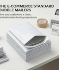 Stack of Bubble Mailers 6 Point 5 By 10 Self Seal Padded Envelopes White 250 Pack on a desk with packaging tools