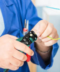 Hands using Heavy Duty Automatic Wire Stripper And Adjustable Crimping Tool For Precise Electrical Wiring on green wire.