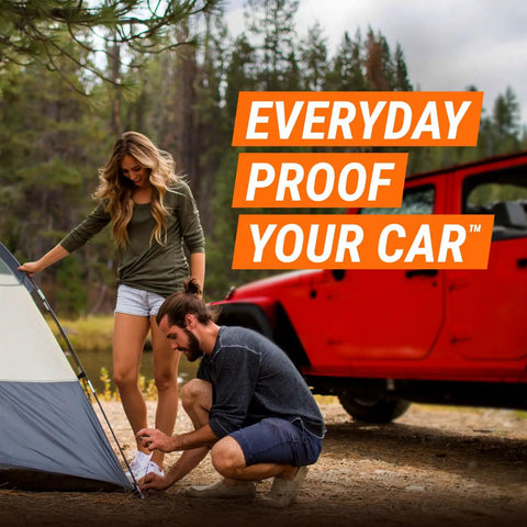 Couple setting up a tent in the woods near a red car with text 'Everyday Proof Your Car'