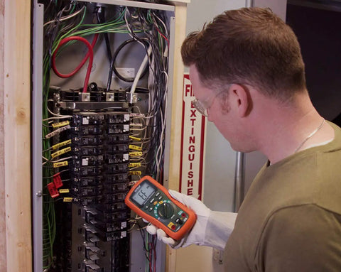 Technician using Datalogging Cat IV True RMS Multimeter With Bluetooth Connectivity on electrical panel