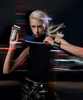Model holding a portable handheld turbo fan with high speed air, wearing a black top in an urban night setting.