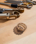 Vintage brass ring pull handle from six piece set on wood, part of Six Piece Set Vintage Brass Ring Pull Handles For Cabinets And Drawers Retro Bronze Hardware With Screws Easy Install Multipurpose Antique Vibe Knobs For Kitchen Dressers And Cupboards.
