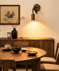 Adjustable Gooseneck Wall Sconce, Modern Wood Grain Wall Lamp illuminating a dining area with wooden decor and tableware.