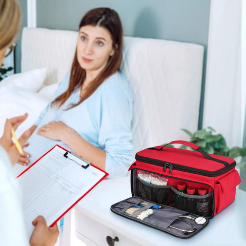 Mancro red first aid bag, front view with open pockets and medical supplies; patient and clinician in background.