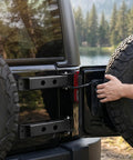 Heavy Duty Tailgate Hinge Set For Jeep Wrangler JK and JKU 2007 through 2018 shown on a black Jeep during tire maintenance.