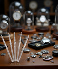 Five Piece Silver Steel Watch Stem Crown Kit For NH35 NH36 NH38 NH39 Movements on wooden table with watch parts