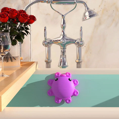 Hot Pink Silicone Bathtub Overflow Drain Cover For A Deeper Soak in use on bathtub, showing octopus suction cups.