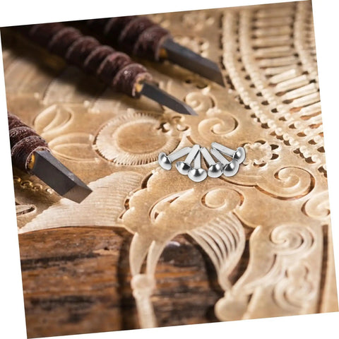 Close-up of 100 Pcs Iron Brads For Paper Crafting And Puppet Making Kit on an intricately carved wooden background.
