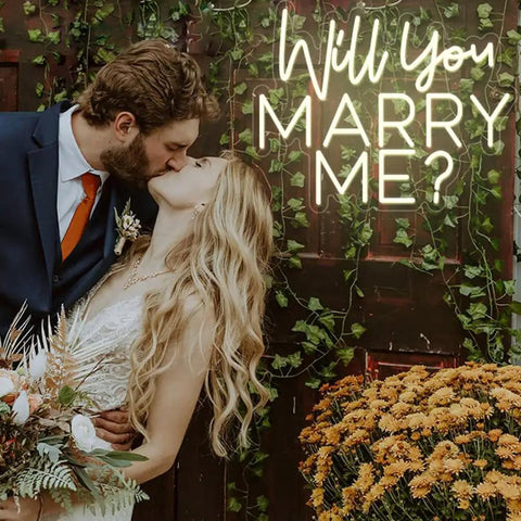 Couple kissing next to Will You Marry Me Neon Sign LED Proposal Light With Acrylic Backboard Large Marry Me Decor.