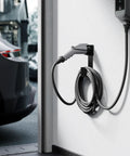 Heavy Duty Stainless Steel EV Charger Holder For J1772 Connectors Wall Mount Cable Organizer installed next to a car.