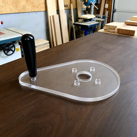 Score Your Shop Upgrade With This Six By Nine Inch Clear Acrylic Router Base Plate Built Straight For Makita Compact Models Featuring Pre Drilled Mounting Holes And Three Eighth Inch Thickness For Rock Solid Precision Woodworking, showing clear acrylic base with handle.
