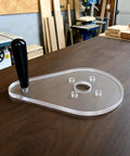 Straight Up Precision Replacement Router Base Plate For Compact Power Tools, 6 By 9 Inch clear acrylic with handle on wood table.