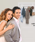 Peasulin white over-the-door hook rack with 12 hooks, installed on a door for towels and coats.