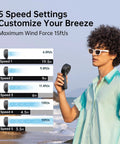 Person holding 3 In 1 Handheld Fan With 5000mAh Battery, 12 Blade Brushless Motor Power, 5 Speed Settings, at beach.