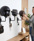 Woman using Six Pack Motorcycle Helmet Rack Wall Mount With 180 Degree Rotation And Dual Hooks in garage for helmets and gear