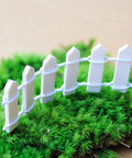 Four Piece 35 Inch White Wood Picket Fairy Garden Fence Set for Dollhouse Miniatures and Home Garden Displays on moss