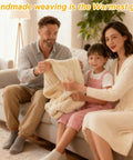 Family sitting on a sofa holding a chunky knit blanket, emphasizing homemade weaving as the warmest gift.