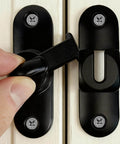 Close-up of a 90/180 Degree Barn Door Lock With Flip Latches, Heavy Duty Black Zinc Alloy Hardware, installed on a white surface