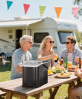 Countertop Ice Maker With Sturdy Carry Handle, Portable Ice Machine Freezing Bullet Ice Cubes In Rapid Six Minutes, Delivers Twenty Six Pounds Daily, Lowkey Essential Home And Tailgate Chiller In Jet Black on picnic table with friends.