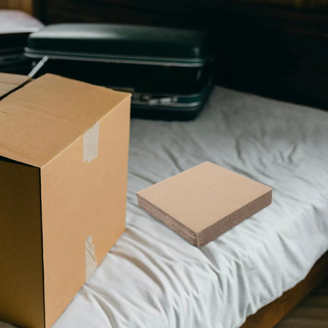 12 Pack Corrugated Paper Filler Sheets for Moving and Shipping cut to size cardboard padding on a bed with box.