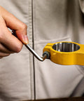 Person using wrench on yellow tool from All Purpose Home Tool Kit With Plastic Toolbox Storage Case 50 Piece Essential Set For DIY Projects