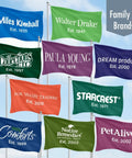 Various brand flags on poles displaying names and establishment years in colorful designs against a blue sky backdrop.