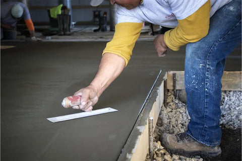 Worker using PermaShape Finishing Trowel 12 X 5 Inch with DuraSoft Handle on concrete slab
