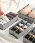 Four Piece Slick Underwear Storage Organizers Featuring Nifty Grid Layouts For Foldable Oxford Fabric Drawer Bins And Wardrobe Packing Boxes, arranged with rolled socks and bras.
