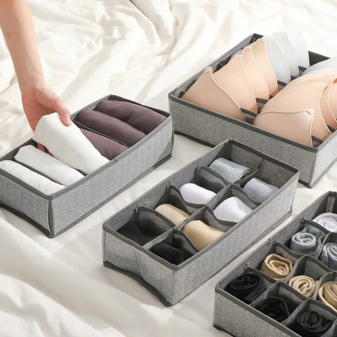 Four Piece Slick Underwear Storage Organizers Featuring Nifty Grid Layouts For Foldable Oxford Fabric Drawer Bins And Wardrobe Packing Boxes, arranged with rolled socks and bras.