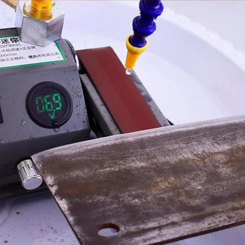Mini Electric Wet Dry Bench Sander With Variable Speed Control Up To 13000Rpm And Lcd Display featuring abrasive belt and water drip for grinding.