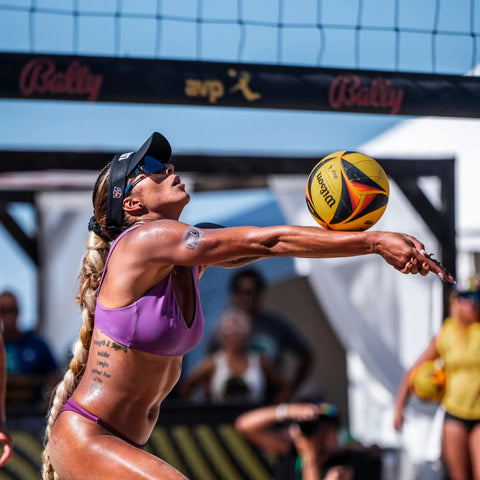 Player in action with AVP OPTX Game Volleyball Official Size Yellow Black For Beach Play during a competitive sand session