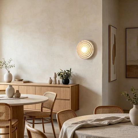 MECOLA Round Resin Accent Wall Sconce Small Glass Globe Shade Wall Lamp mounted on wall in a cozy dining area.