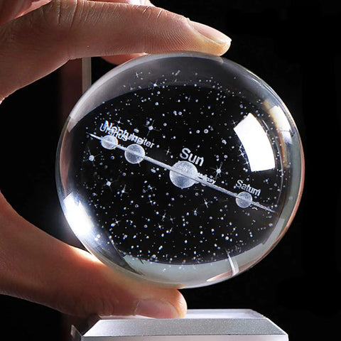 Stellar 80mm Solar System Crystal Ball Glass Sphere with 3D Laser Engraved Planets, K9 Crystal, held by hand, close-up view.