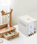 3A Electroplating Machine For Jewelry, 110V Pro Grade Gold And Silver Plating Power Supply With Real Time Voltage Meters on workspace with jewelry organizer.