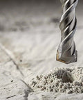 Close-up of carbide-tipped masonry drill bit drilling into concrete, 12mm x 200mm SDS bit
