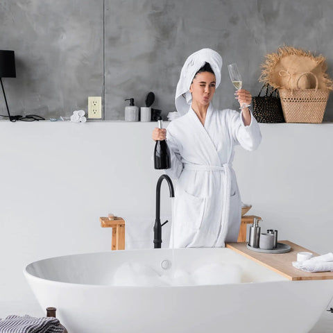 Person in robe holding champagne in modern bathroom with Slim GFCI Outlets 10 Pack 15A 125V ETL Listed Non Tamper Resistant Duplex Receptacles.