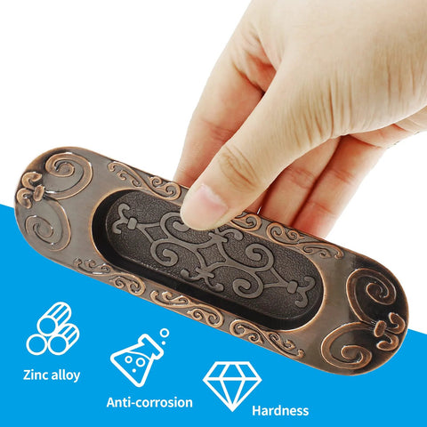 Hand holding Two Pack 4.13 Inch European Recessed Flush Pull Handle in Antique Copper Finish for sliding doors with labels zinc alloy, anti-corrosion, and hardness.