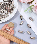 50 Pack Stainless Steel Arrow Field Tips 8mm Glue On Points for Target Practice next to ruler and coin for size comparison