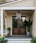 Large Twenty Five Inch Outdoor Pendant Light With Clear Glass And Sturdy Metal Build straight up above a porch entrance.