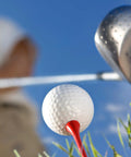 Close-up of a golf ball on a Two And Three Quarter Inch Red Wood Golf Tees Pack Of 100 Built For Real Players With Pro Grade Performance