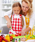 Toy 46-piece kids knife set with cutting board; child slices vegetables under adult supervision